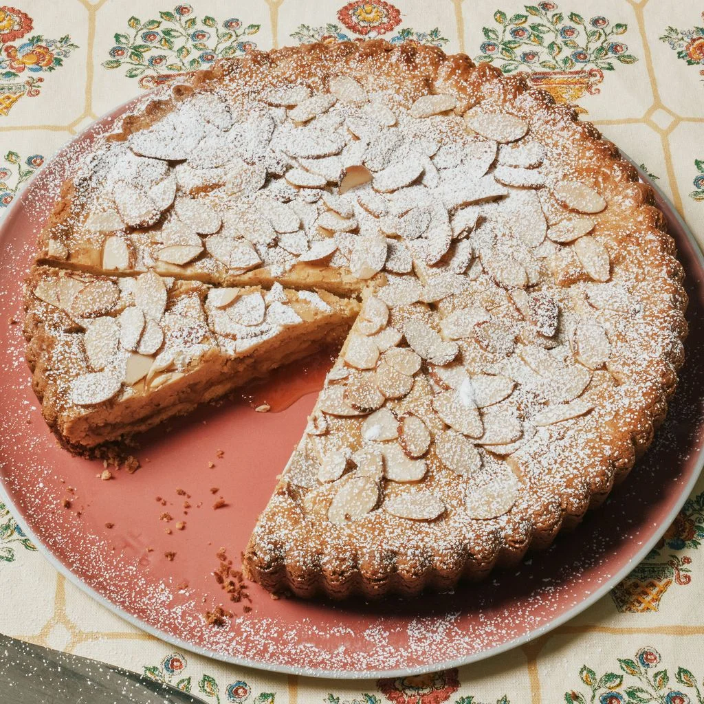 An almond apricot crostata sliced on a cake plate.