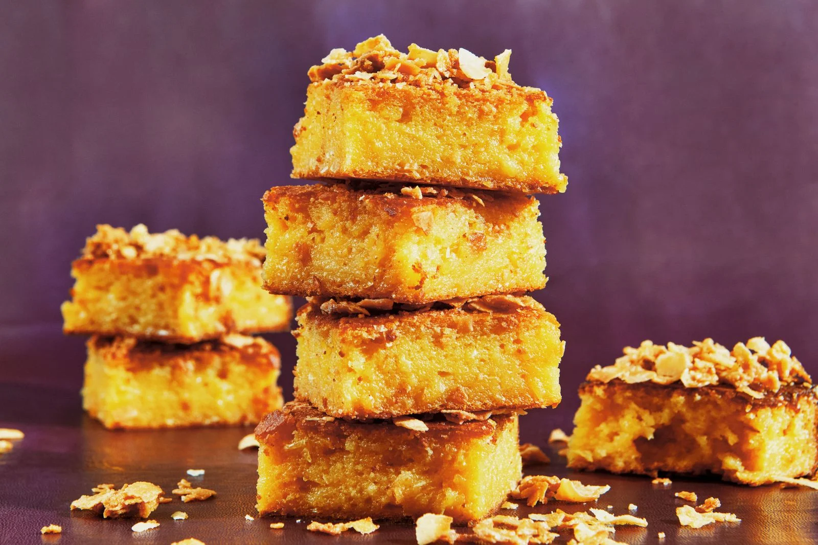 Several stacks of sweet corncoconut crunch butter mochi cake squares.