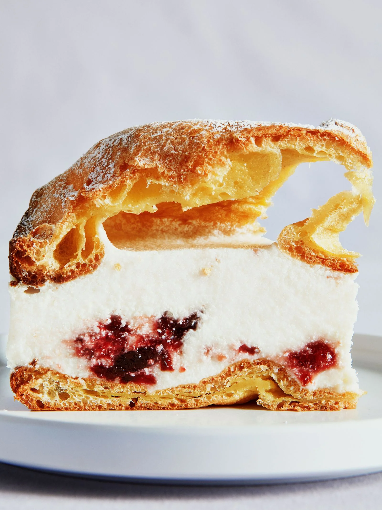 A slice of plum cheesecake karpatka on a plate.