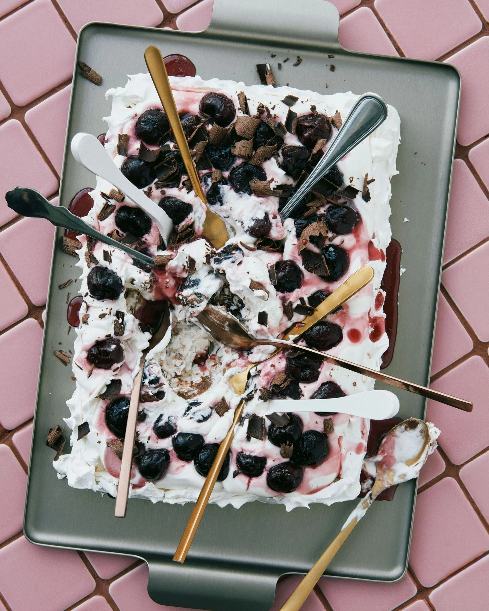 A meringue crust with chocolate ganache and marshmallow layers topped with frozen dark cherries shaved chocolate and...