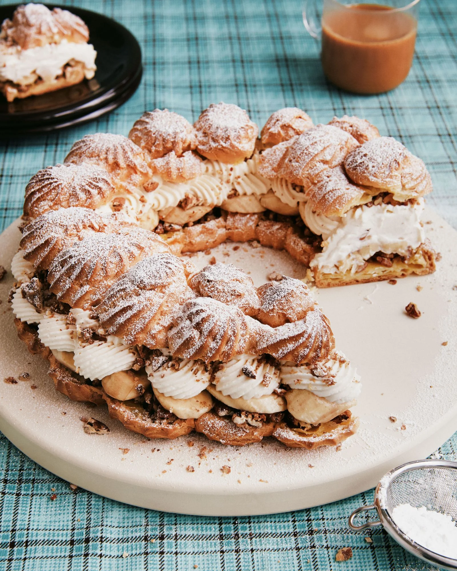 Candied pecans slice bananas and Diplomat Cream between two layers of choux pastry and dusted with confectioner's sugar.
