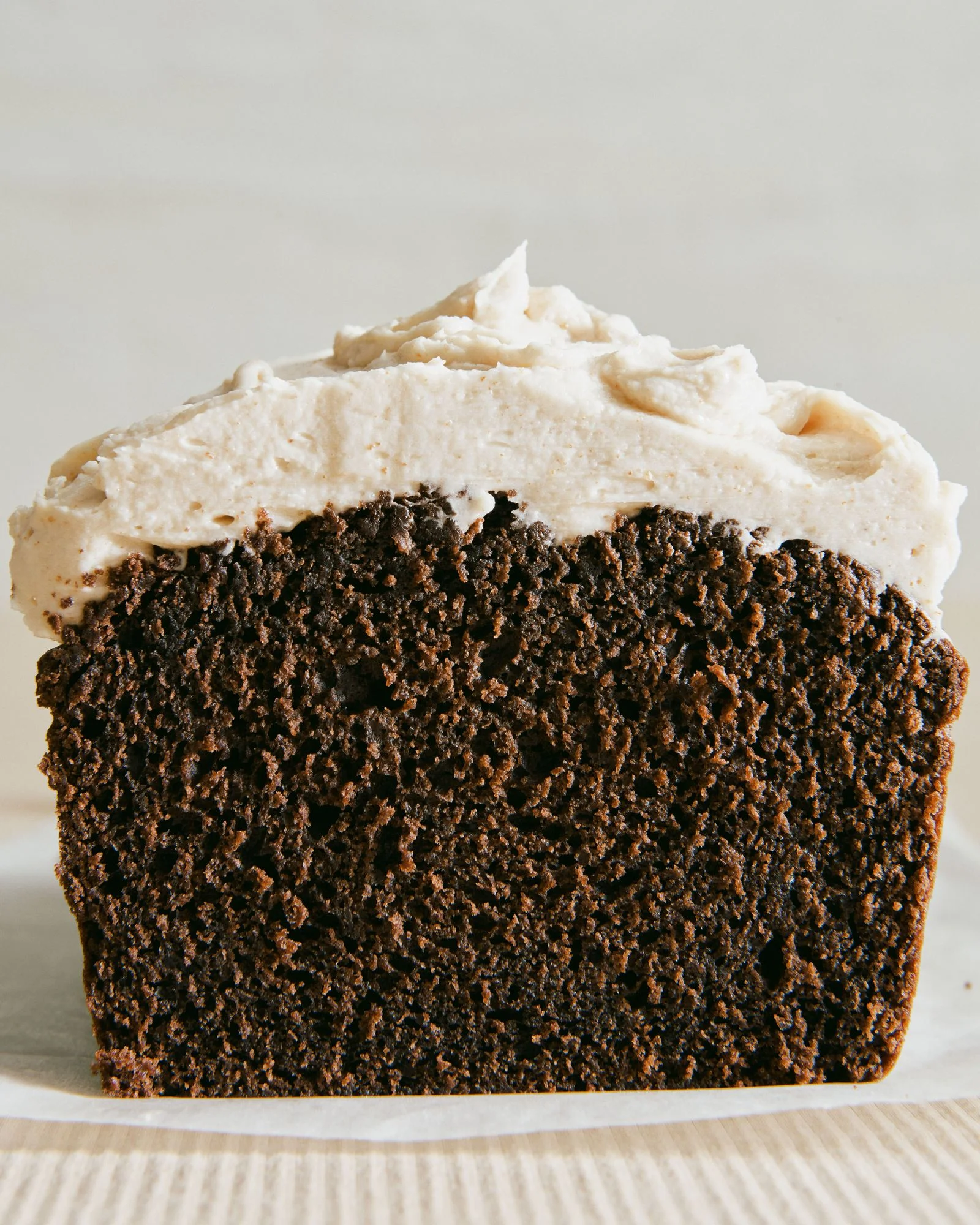 A chocolate loaf cake made with Guinness stout and topped with brown butter frosting cut in half.