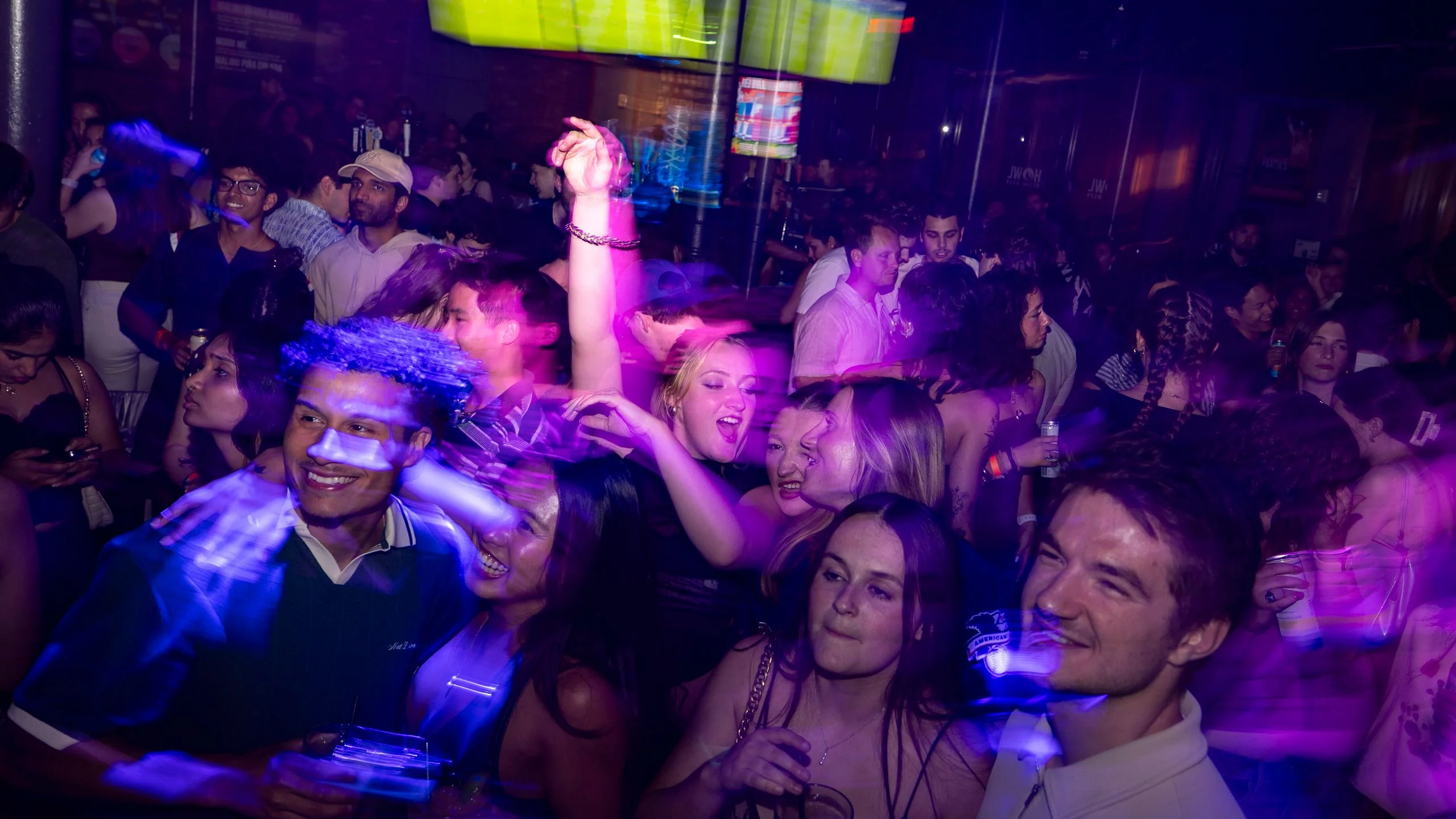 People dance at a dimly lit club called Howl at the Moon