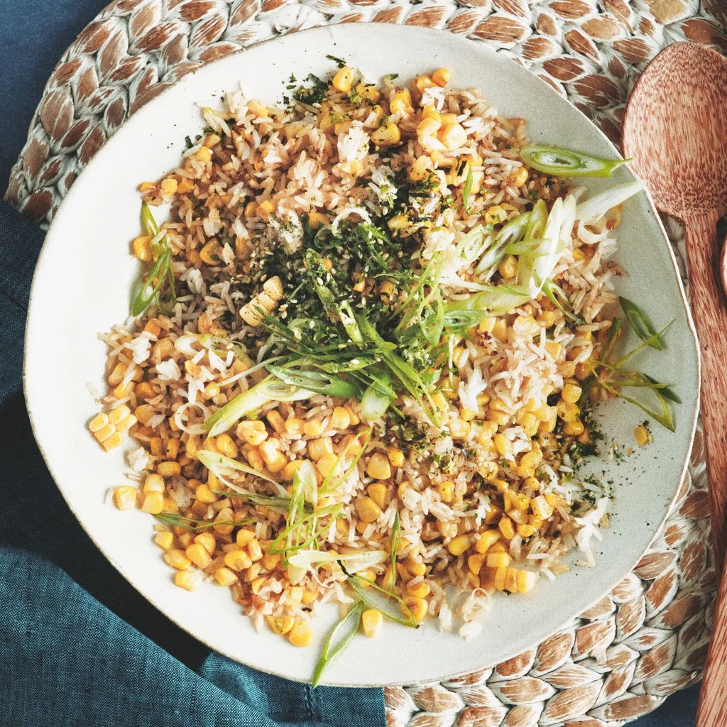 Sweet corn fried rice furikake and thinly sliced scallions in a serving bowl.