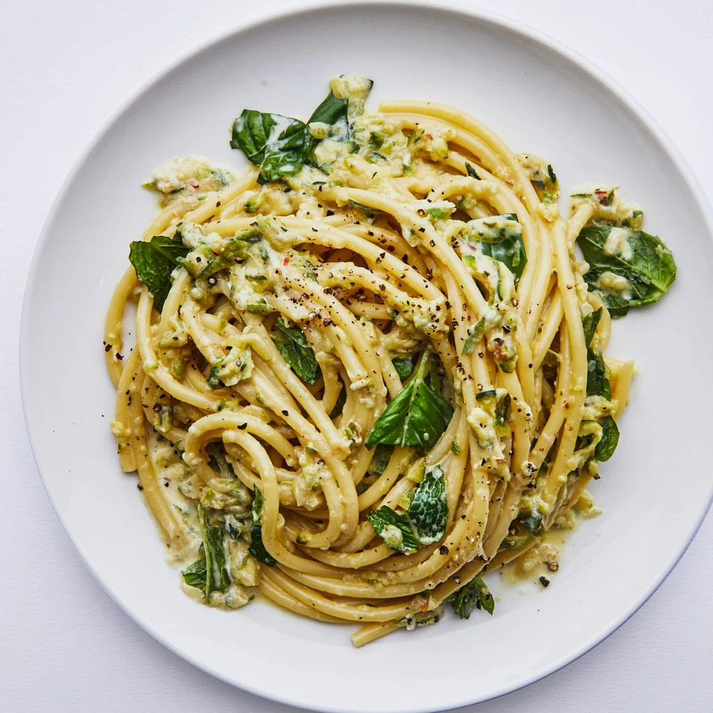 Bowl of creamy lemon zucchini pasta with basil and mint.