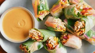 Shredded roast chicken julienned mango carrots cucumbers pickled radishes cilantro leaves and iceberg lettuce wrapped in...