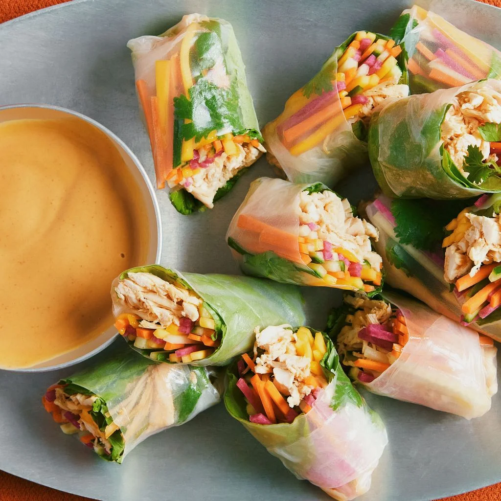 Shredded roast chicken julienned mango carrots cucumbers pickled radishes cilantro leaves and iceberg lettuce wrapped in...