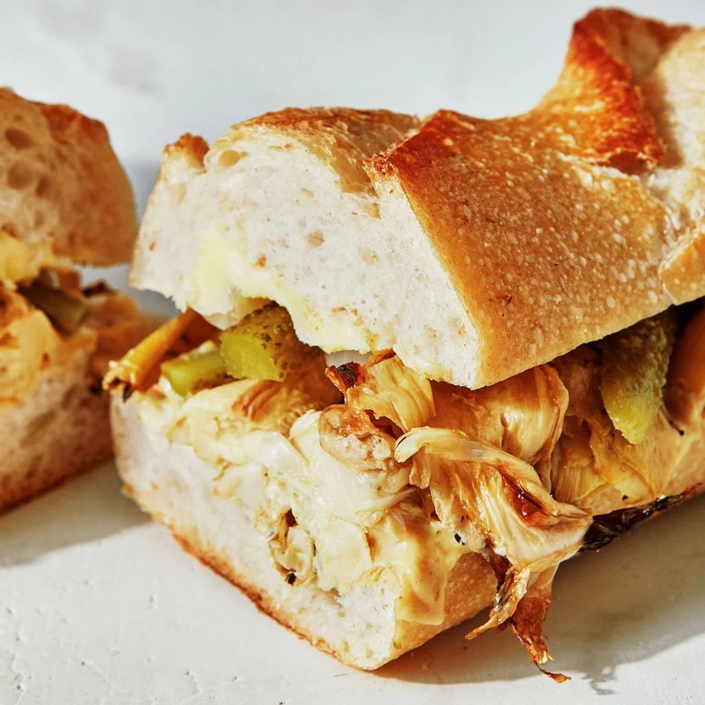 Broiled artichoke hearts sliced cornichons and pearl onions butter and Dijon mustard in a sliced baguette.