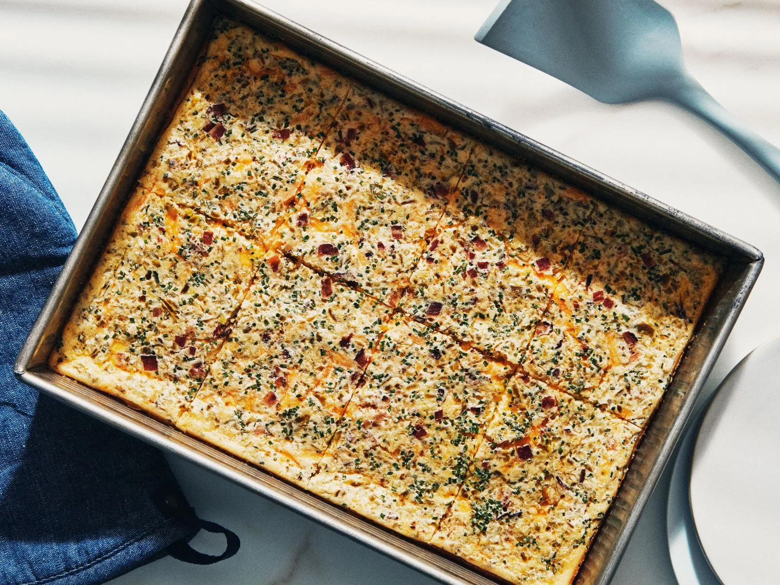 A egg casserole with cornbread chopped bacon and chives.