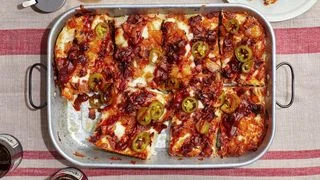 A Hawaiian Detroitstyle pizza with barbecue sauce beef bacon pineapplea nd pickled jalapeños.