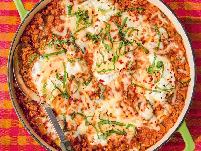Ground turkey tomato sauce ricotta cheese and mozzarella baked in a skillet and topped with julienned basil leaves and...