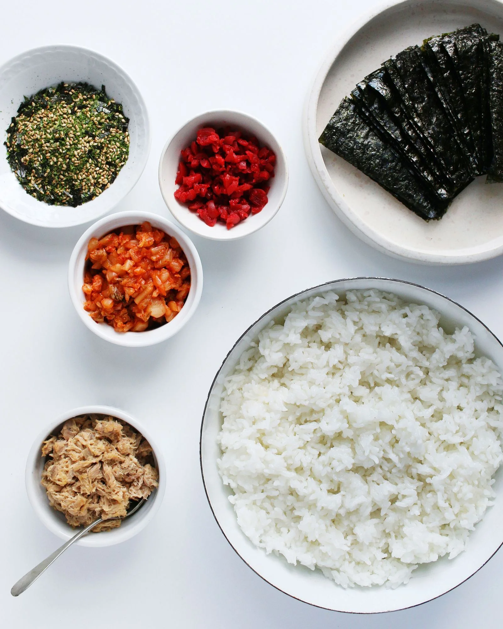 Assembly for onigiri including cooked rice canned tuna chopped kimchi chopped umeboshi furikake and nori sheets