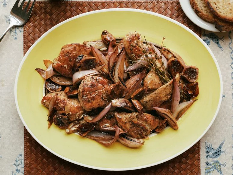 Chicken thighs cooked in black vinegar with shallots thyme and figs served with bread.