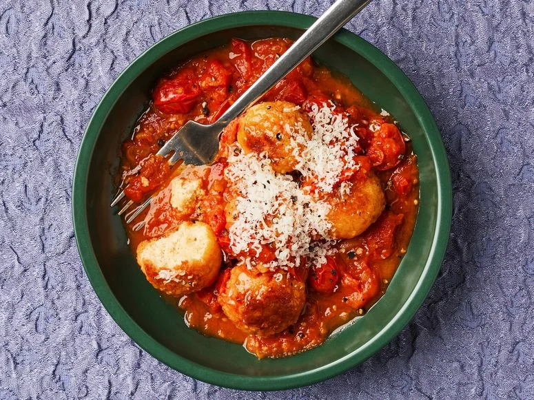 Tofu meatballs in a bowl with tomato sauce.