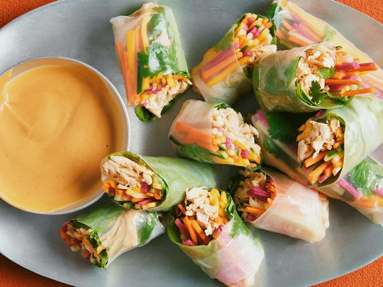 Shredded roast chicken julienned mango carrots cucumbers pickled radishes cilantro leaves and iceberg lettuce wrapped in...