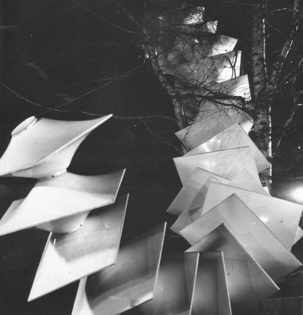 Agostino Bonalumi, 'Struttura modulare bianca,' 1970, installed outdoors at the 12th Biennale of Middelheim, Antwerp. Black and white photograph showing the large-scale modular white sculpture among trees, its repeating angular geometric forms rising dramatically against a dark background. Courtesy Archivio Bonalumi.