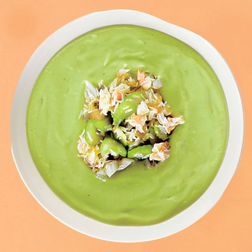 A bowl of bright green chilled avocado soup topped with crab salad.