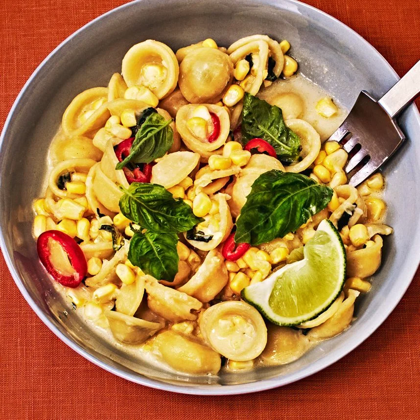 Orecchiette With Fresh Corn in a skillet on a orange fabric