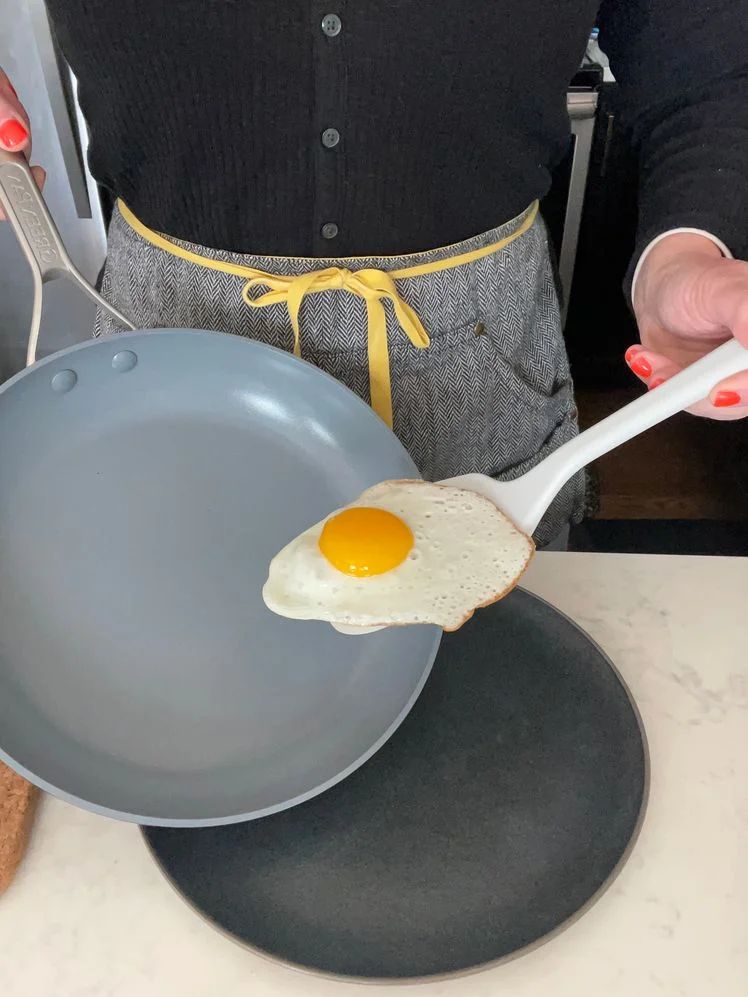 A person using a spatula to slide a fried egg out of a GreenPan Paris Pro nonstick pan.