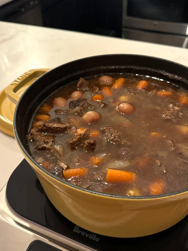 Meat stew brewing in yellow Staub.