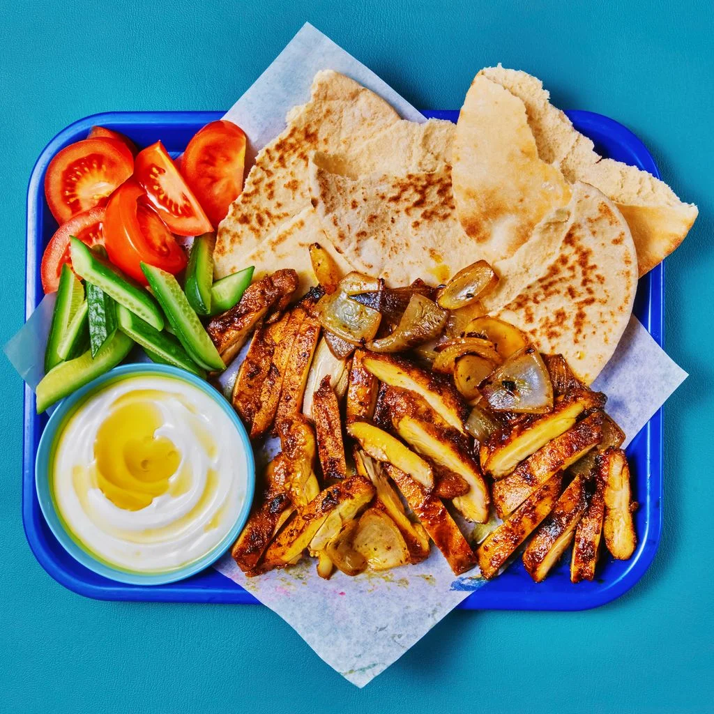 Sheet Pan Shwarmaish Chicken on a blue tray that is place on a blue background