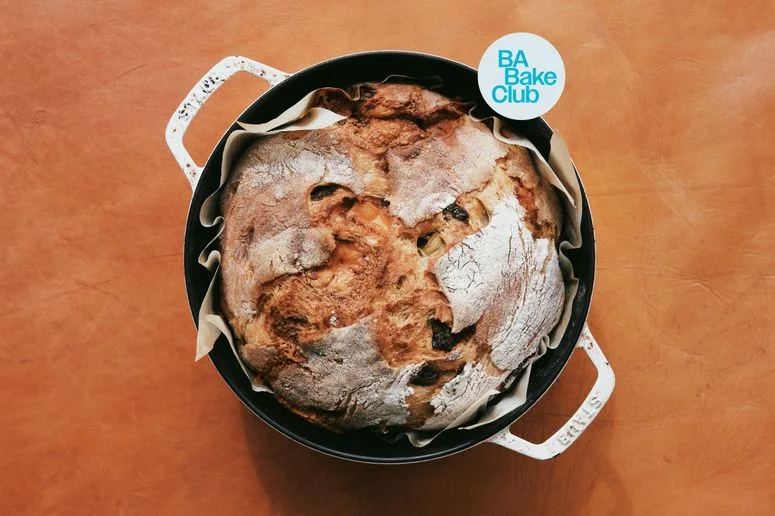 A boule of cheddar jalapeño bread in a dutch oven.