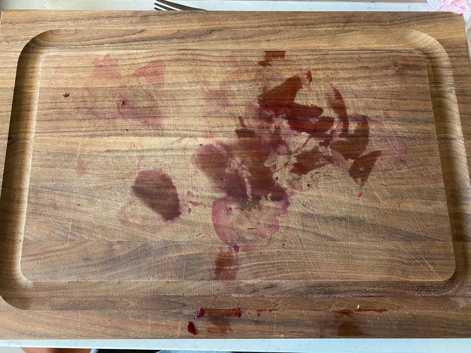 A wood cutting board with beet stains.