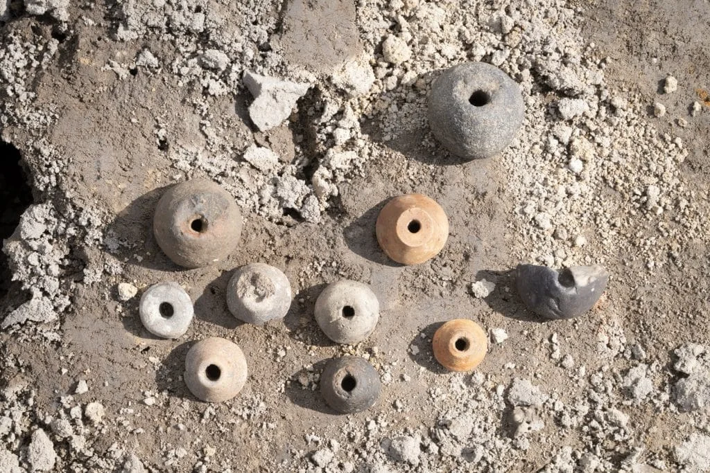 an aerial view of nine round loom weights on the ground that are dated to the Viking Age.